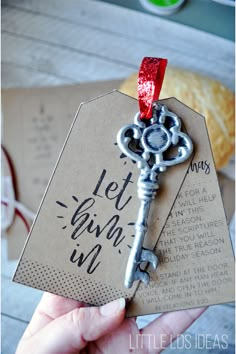 a person holding a key shaped like a card with a red ribbon on the top