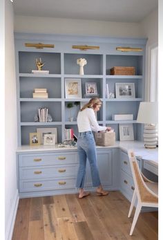 a woman standing in front of a blue bookcase