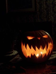 a carved pumpkin with glowing eyes in the dark