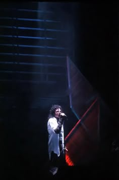 a man standing on top of a stage holding a microphone