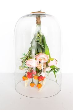 a glass clochel with flowers in it