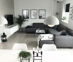 a living room filled with lots of furniture next to a white dining table and chairs