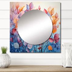 a mirror sitting on top of a wooden table next to a vase and potted plant