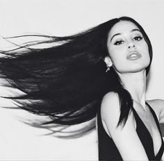 a black and white photo of a woman with her hair blowing in the wind,