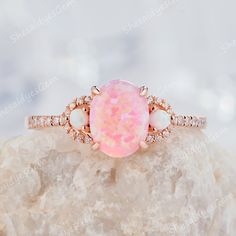 A classical vintage oval opal ring in 10K 14k or 18k gold, pictured in rose gold. Unique oval cut pink fire opal engagement ring, wedding ring, anniversary ring gift for girl, women, best friend, wife and her. The opal is a representative of justice and harmony, and is a protective stone in dangerous places.  ITEM DESCRIPTION ★Center Stone: 0.8 Carat 8x6mm Oval Cut Lab Pink Fire Opal ★Side Stone: 2mm round cut lab created white opal  ★Accent Stone:0.18CT Diamonds or Moissanite   Accent Stone: Cubic Zircon with Silver Ring ★Shank Width(Bottom):1.5mm *Purchase Guarantee: 1: Provide you with the best service. 2: 30 Days Refund Guarantee. 3: Free Gift Box and Packing. *Processing time: When we receive payment We need 2-3 weeks to work for your items in perfect by hand. Please contact us if you Pink Fire, Cute Engagement Rings, Opal Wedding Rings, Opal Wedding, Future Engagement Rings, Opal Engagement Ring, Promise Ring Gift, Opal Engagement, Engagement Rings Opal