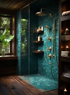 a walk in shower sitting next to a window with candles on the shelves and a potted plant