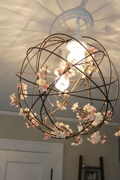 a chandelier hanging from the ceiling with flowers on it