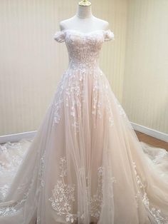 a white wedding dress on display in a room with a mannequin headdress