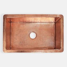 a square copper sink with an oval hole in the center, on a white background