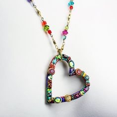 This heart hoop necklace embellished with a wide variety of multi-color Swarovski crystal and glass beads set into rainbow enamel placed on a chain beaded with Swarovski crystals and glass beads is inspired by it's own abstract and bright shape. This handmade piece is a one of a kind, fashionable statement necklace that will be perfect for any spring outfit or as a lovely gift for valentine's day.Pendant Length: 1.75 inchesPendant Width: 1.5 inchesNecklace Length: 20.25 inchesAdditional Extender Valentine's Day Beaded Metal Jewelry, Multicolor Jeweled Necklaces With Round Beads, Colorful Bohemian Jewelry With Heart Beads, Colorful Bohemian Heart Beads Jewelry, Multicolor Crystal Beaded Chain Jewelry, Multicolor Enamel Jewelry With Lobster Clasp, Multicolor Jeweled Enamel Jewelry, Multicolor Crystal Beaded Jewelry, Multicolor Beaded Crystal Jewelry