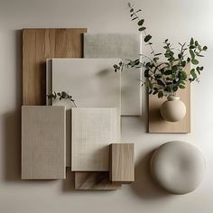 a white vase sitting on top of a wooden shelf next to a wall mounted plant