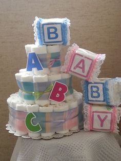 a diaper cake with blocks and letters on the top that spell out abc, baby