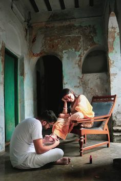 two people sitting on a chair in an old building