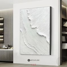 a large white painting hanging on the wall in a living room next to a sink