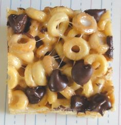 a square piece of food that has chocolate and nuts on it