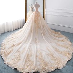 a wedding dress is displayed in front of a mirror