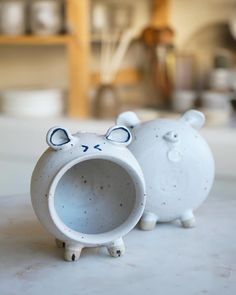 two ceramic animals sitting next to each other on a table