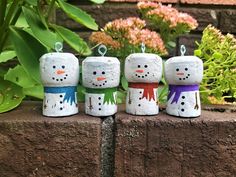 four snowmen sitting on top of a brick wall