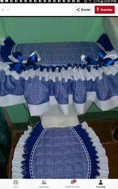 a toilet covered in blue and white checkered cloths with bows on the top