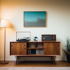 an old record player is sitting on top of a wooden cabinet next to a lamp