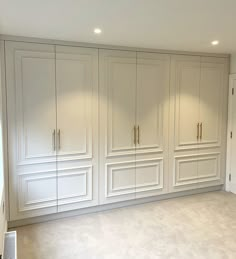 an empty room with white cabinets in it