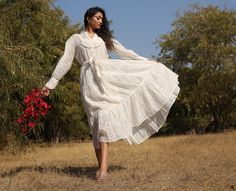 This beautiful white on white printed dress is made in #sheer cotton-silk from Banaras, India. It has a collared neckline with hand-embroidered frill trims and buttons till the waist. The sleeves are gathered and end in a wide cuff with frill trims and buttons. With a tiered flare, this dress is feminine and comfortable to move in. The dress comes with an adjustable waist tie finished with neatly hand-embroidered frill trim. A treat for all women who possess a #romantic style! The print, embroid White Spring Dress With Ruffled Collar, White Dress With Ruffled Collar For Spring, White Summer Dress With Ruffled Collar, White Dresses With Ruffled Collar For Spring, White Cotton Voile Summer Dress, Summer Cotton Voile Dress With Ruffles, White Cotton Dress With Ruffled Collar, White Swiss Dot Cotton Dress, White Feminine Dress With Ruffled Collar