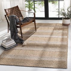 a living room with a chair, rug and window in the background that has plants on it