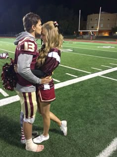 a man and woman standing on top of a football field