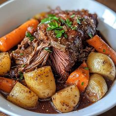 a white bowl filled with meat, potatoes and carrots