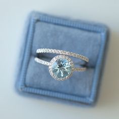 an engagement ring with a blue topaz surrounded by white diamonds in a gift box