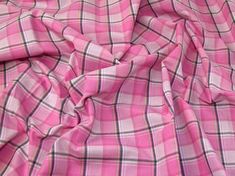 a pink plaid fabric with black and white lines on it's edges, as well as the top part of its bottom half