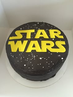 a black and yellow cake with the words star wars on it