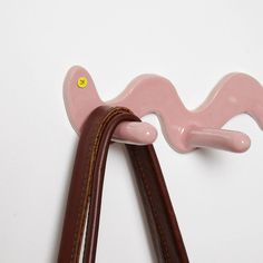 a pink and brown leather handle on a white wall