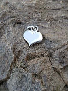 Garnet Sterling Silver Heart Pendant Cute solid sterling silver flat heart pendant with a since round pink Garnet (possibly tourmaline) cabochon bezel set. Perfect for your self or as a gift. Small enough to be a pendant or worn on a charm bracelet. Marked Sterling Measures 18mm by 11.9mm. Stone measures about 2mm Vintage good condition Stone origin, treatments unknown. Tested on Presidium Gem Tester II. White Gold Heart Pendant Charms For Valentine's Day, White Gold Heart Charms In Sterling Silver, Heart-shaped White Gold Sterling Silver Charms, White Gold Heart Pendant Charm In Sterling Silver, Silver Heart-shaped Charm For Valentine's Day, White Gold Sterling Silver Heart Charms, Silver Heart Pendant Charms For Valentine's Day, Silver Heart Charm For Valentine's Day, Silver Heart Charms For Valentine's Day