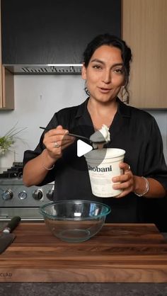 a woman holding a bowl and spoon in her hand