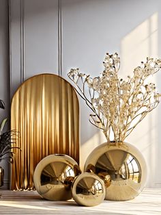 two vases with flowers in them sitting on a table next to a gold sculpture