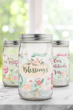 three mason jars sitting on top of a table next to each other with stickers