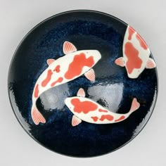 two orange and white koi fish on a blue plate