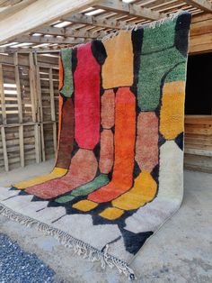 a multicolored area rug on the ground