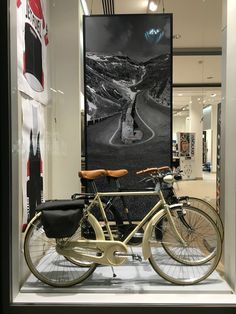 a bicycle is parked in front of a large poster on the wall inside a store