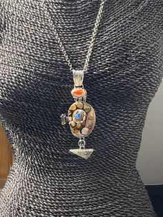 "Long Artisan Fossil with opals pendant Hand-made Sterling Silver 925. Stones used: Ammonite-fossil, Mexican Fire Opal, Pearl, Mystic Topaz, Fossil Coral, Australian Opal Height - 4\" (with bail), Width - 1 5/8\" Height -100mm (with bail), Width - 42mm Unique Handcrafted One-of a-kind Design Pendant Each Piece of Jewelry in my Collection is Absolutely One of a Kind! When you start wearing a piece of my jewelry you will fall in love with it more and more each day and feel that good Energy and Lov Artisan Silver Opal Jewelry, Silver Fusion Necklace With Cabochon, Silver Opal Fusion Jewelry, Pendant Amulet Necklace With Cabochon, Opal Cabochon Pendant Necklace, One Of A Kind Silver Opal Jewelry, One-of-a-kind Silver Opal Jewelry, Silver Pendant Necklace With Inlay, Cabochon Amulet Pendant Necklace