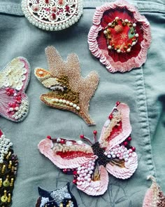 several different types of brooches on a piece of cloth with beads and bead work