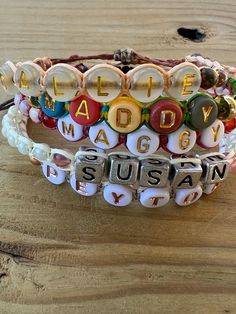 three different bracelets with words on them sitting on a wooden table, one saying made easy and the other saying sustenance