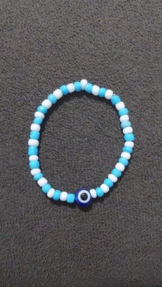 a blue and white beaded bracelet with an evil eye