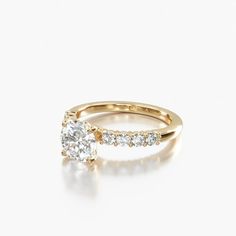 a yellow gold engagement ring with an oval cut diamond in the center and side stones