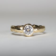 a gold ring with a white diamond in the center