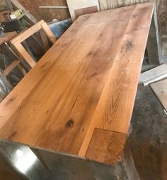 a wooden table sitting in the middle of a room next to other tables and chairs