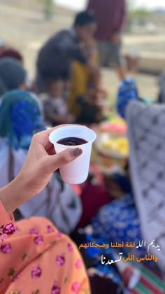 a woman holding a cup of coffee in her hand