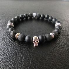 Elevate your style with this stunning handmade matte black onyx and lava rock bracelet, adorned with a Tibetan silver scalp charm. This one-of-a-kind piece is the perfect accessory for any occasion, making it an excellent choice for a unique gift for him or her. 🌟 Key Features:  ▪ Handcrafted with precision and care  ▪ Premium quality matte black onyx and lava rock beads  ▪ Tibetan silver scalp charm for a touch of uniqueness  ▪ Adjustable to fit most wrist sizes  ▪ Versatile enough for women and men 💖 Show your loved ones how much you care with this exquisite handmade bracelet. It's a meaningful way to express your feelings and create lasting memories. 🖤 Add a touch of sophistication to your style with the healing properties of matte black onyx and the grounding energy of lava rock. Th Minimalist Black Beaded Bracelets With Natural Stones, Minimalist Black Beaded Bracelet With Natural Stones, Black Lava Stone Beaded Bracelets, Adjustable Black Lava Stone Beaded Bracelets, Adjustable Black Lava Stone Bracelet, Black Lava Stone Bracelets With Gemstone Beads, Handmade Onyx Black Bracelets, Black Lava Stone Bracelet With Gemstone Beads, Handmade Black Onyx Bracelets