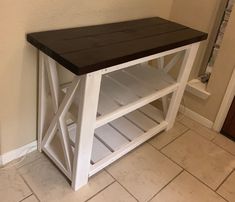 a wooden table with shelves on top of it in a room next to a door